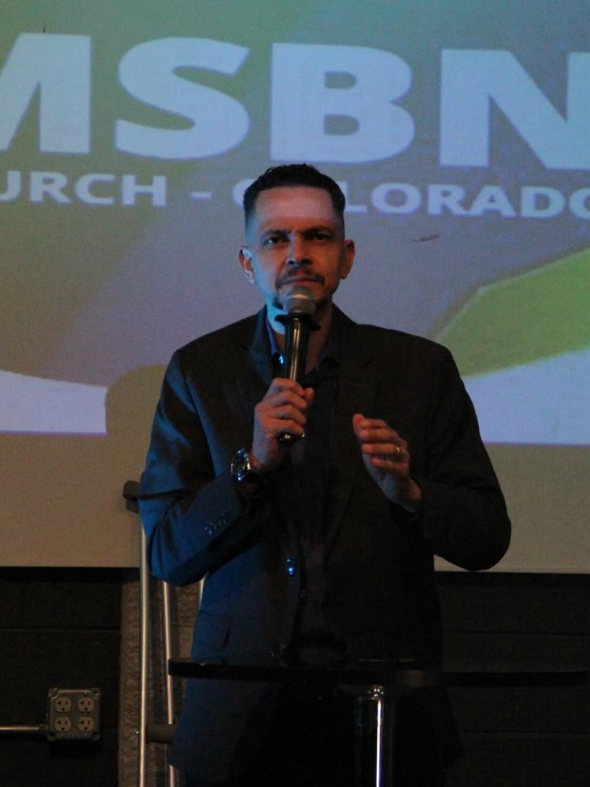 Pr. Leone Passos ministrando com um microfone